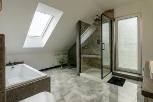 a bathroom with a shower and a tub and a sink at Apartament Nowinka in Tatary