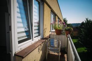 a chair sitting on a balcony with a window at CK-Apartment in Český Krumlov