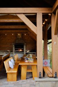 a patio with a table and benches and a fireplace at Góralskie Domki in Szczawnica