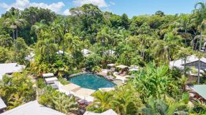 an aerial view of a resort pool with palm trees at NALA Resort in Mission Beach