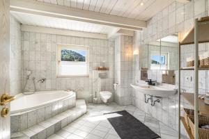 a bathroom with a tub and a sink and a toilet at Villa Encanto in Albstadt +34 photos