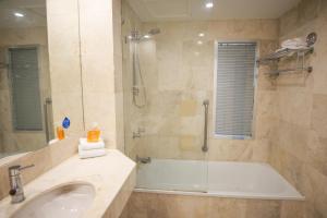 a bathroom with a tub and a sink and a shower at Beachside Studio with Stunning Ocean View in Gold Coast