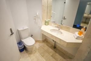 a bathroom with a toilet and a sink and a mirror at Beachside Studio with Stunning Ocean View in Gold Coast +9 photos