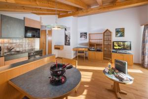 una cucina con tavolo e una sala da pranzo di Helvetia Apartments a Saas-Fee