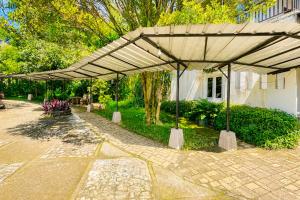 a pavilion in a garden next to a building at Urbanview Hotel RDN Oasis Cisarua by RedDoorz in Brujul