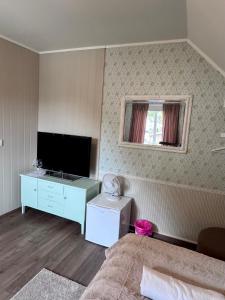 a bedroom with a bed and a tv and a desk at Villa Utsikten Eggen in Åndalsnes