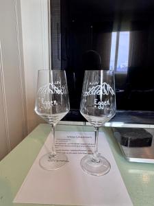 two wine glasses sitting on a paper on a table at Villa Utsikten Eggen in Åndalsnes