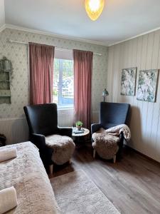 a bedroom with two chairs and a table and a window at Villa Utsikten Eggen in Åndalsnes