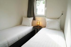 two beds in a room with a candle on a table at EuroParcs Kaatsheuvel in Kaatsheuvel