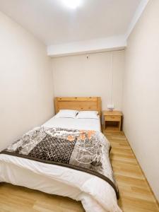 a bedroom with a bed and a wooden floor at Ananda Homestay in Tawang
