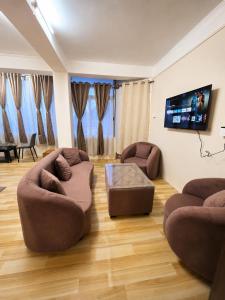 a living room with two couches and a flat screen tv at Ananda Homestay in Tawang