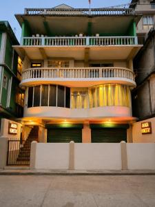 a large building with a balcony on top of it at Ananda Homestay in Tawang