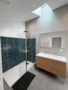 a bathroom with a sink and a shower and a mirror at Maison des Capucins in Nérac