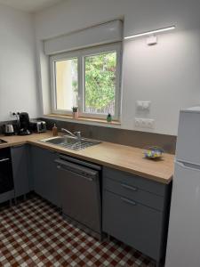 a kitchen with a counter and a sink and a window at Maison des Capucins in Nérac +9 photos