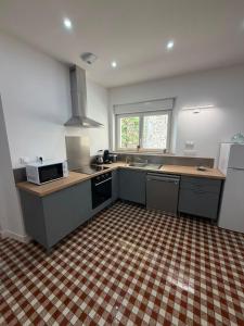 an empty kitchen with a sink and a microwave at Maison des Capucins in Nérac