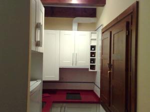 a small kitchen with white cabinets and a red rug at La Casuca de Pechón in Pechón