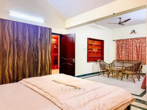 a bedroom with a bed and a table and chairs at CK Beach House in Chennai