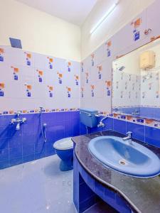 a blue and white bathroom with a toilet and a sink at CK Beach House in Chennai +15 photos