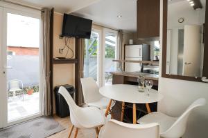 a kitchen and dining room with a white table and chairs at Diófa Vendégház in Pilismarót