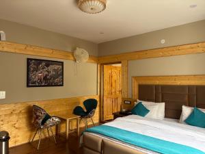 a bedroom with a bed and two chairs at Lavender House in Nubra