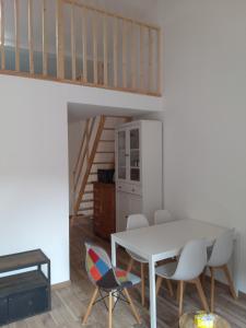 a dining room with a white table and chairs at Entire maisonette in Tarn in Busque