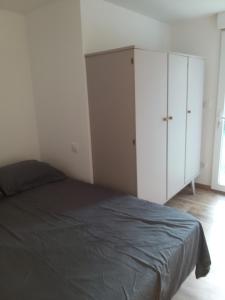 a bedroom with a bed and a white cabinet at Entire maisonette in Tarn in Busque