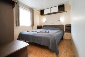 a bedroom with a bed with a blue blanket at Diófa Vendégház in Pilismarót