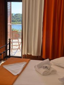 a bed with two towels on it with a view at Liani Ammos in Ammouliani