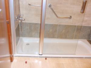 a shower stall with a glass door and a tub at Extremadura Hotel in Cáceres