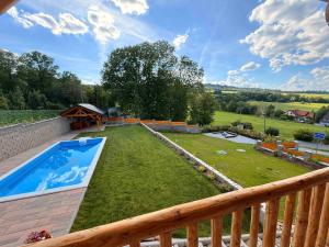 a backyard with a swimming pool and a wooden fence at Srub Chodov in Chodov