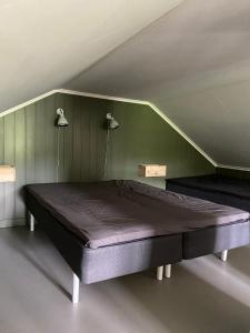 a bed in a room with a green wall at Gårdshus på Kilagårds Gröna in Heberg