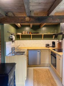 a kitchen with white cabinets and a sink at Gårdshus på Kilagårds Gröna in Heberg