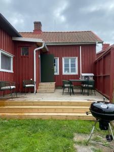 a backyard patio with a bbq and a house at Gårdshus på Kilagårds Gröna in Heberg