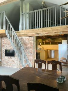 a dining room with a table and a staircase at Gårdshus på Kilagårds Gröna in Heberg