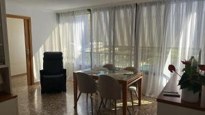 a dining room with a table and chairs and a large window at Apartamento entero en la playa san juan in Alicante