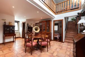 a dining room with a table and chairs and a staircase at IZURRENEA Casa Rural in Arano
