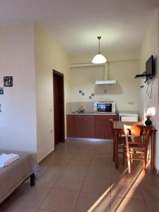 a living room with a table and a kitchen at Xenonas Anopolis 2 in Sinoikismós Kámbos