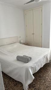 a bedroom with a white bed with a towel on it at Apartamento entero en la playa san juan in Alicante +11 photos