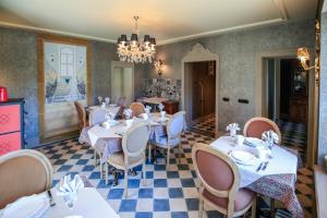 a dining room with tables and chairs and a chandelier at la maison oubliée in Goetzenbruck