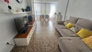 a living room with a couch and a flat screen tv at Apartamento entero en la playa san juan in Alicante