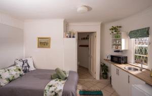 ein kleines Zimmer mit einem Bett und einem Waschbecken in der Unterkunft The Centre Circle in Hilton