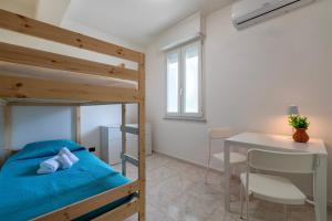 a bedroom with a bunk bed and a table and a desk at Harmony in Nulvi