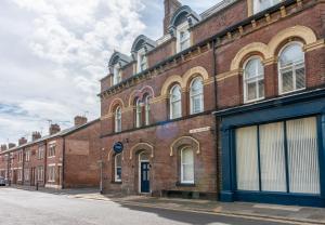 a large brick building on a street at Parade House - A St David Aparthotel in Barrow in Furness