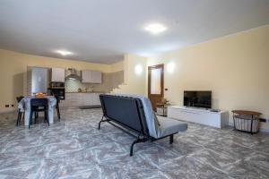 a living room with a chair and a kitchen at Harmony in Nulvi
