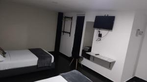 a hotel room with a bed and a tv at Hotel Aura Nutibara in Medellín