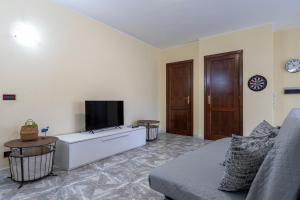 a living room with a couch and a flat screen tv at Harmony in Nulvi