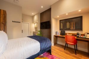 a bedroom with a bed and a desk with a red chair at Parade House - A St David Aparthotel in Barrow in Furness +10 photos