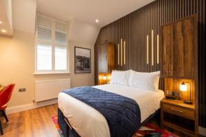 a bedroom with a large bed with a wooden headboard at Parade House - A St David Aparthotel in Barrow in Furness