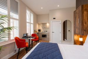 a bedroom with a bed and a desk and a kitchen at Parade House - A St David Aparthotel in Barrow in Furness