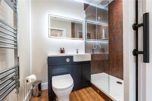 a bathroom with a toilet and a sink and a shower at Parade House - A St David Aparthotel in Barrow in Furness